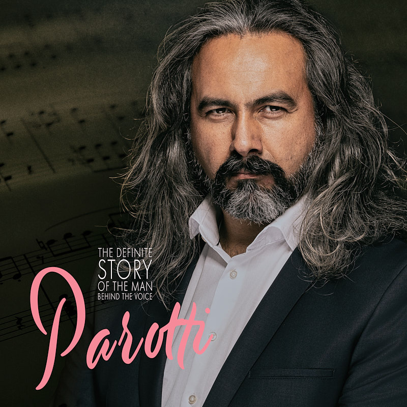 Ausdrucksstarkes Musikerportrait eines Sängers mit langen grauen Haaren und Vollbart vor einem Hintergrund aus Notenblättern, erstellt im Fotostudio Freising.